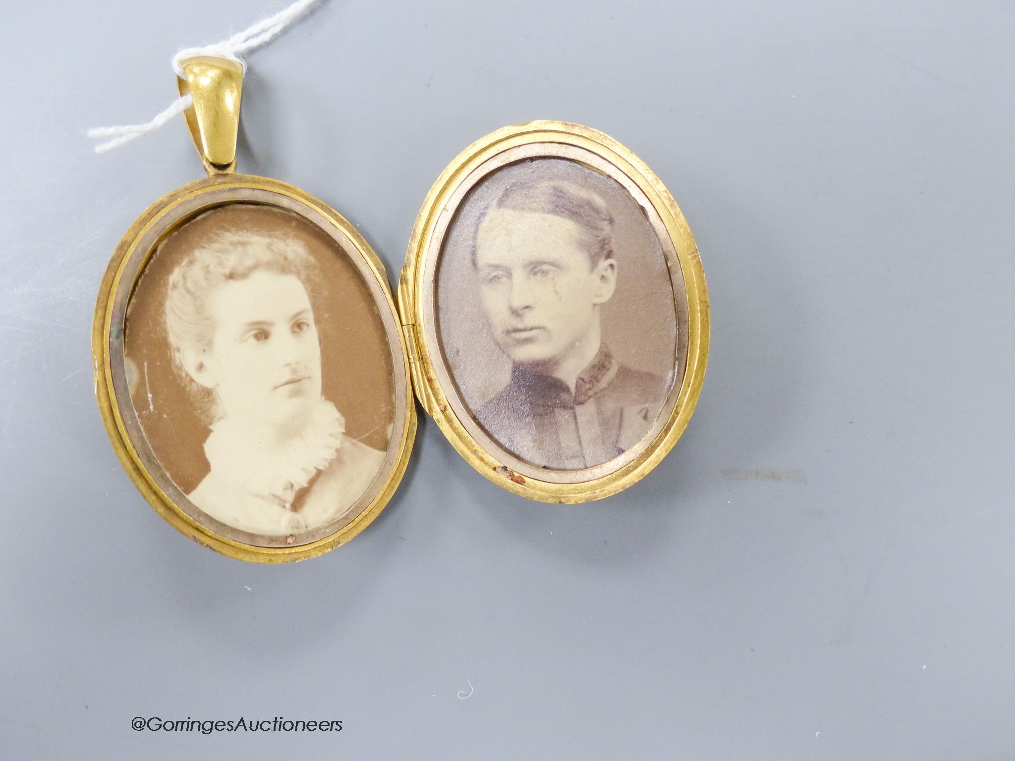 A Victorian yellow metal oval pendant locket with applied monogram, overall 63mm, gross weight 31.9 grams.